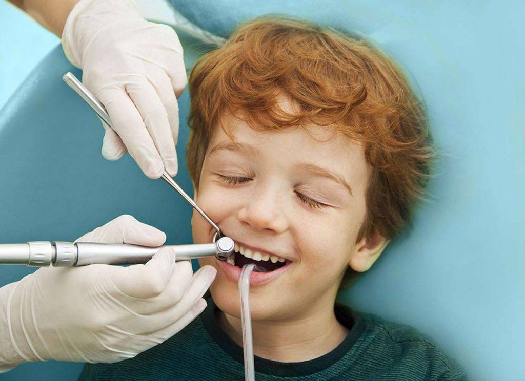 Dentist doing dental treatment on child