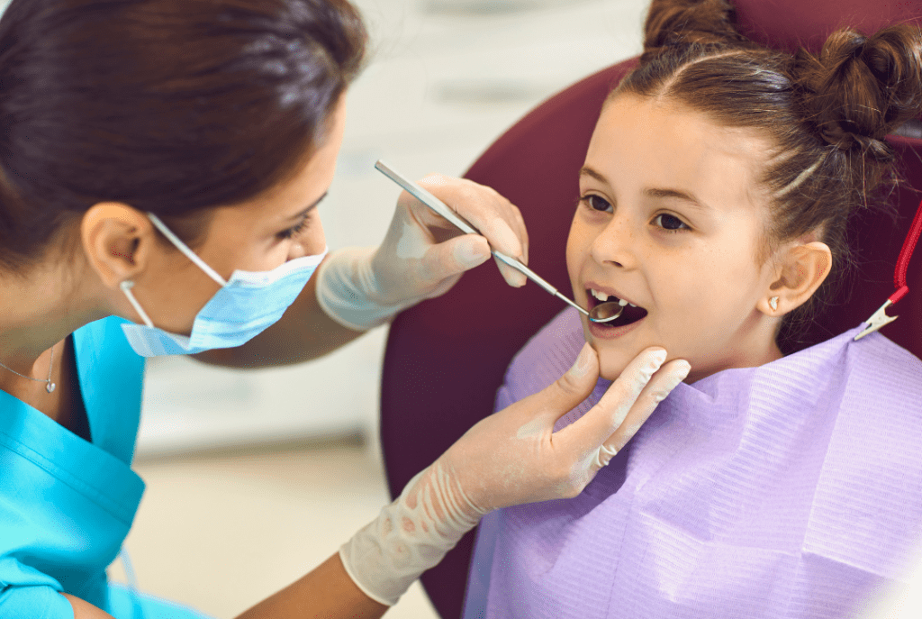 A dentist cares for a smiling child’s teeth