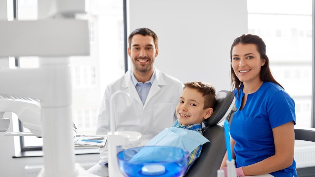 A dentist with a kid and a parent during a dental check up