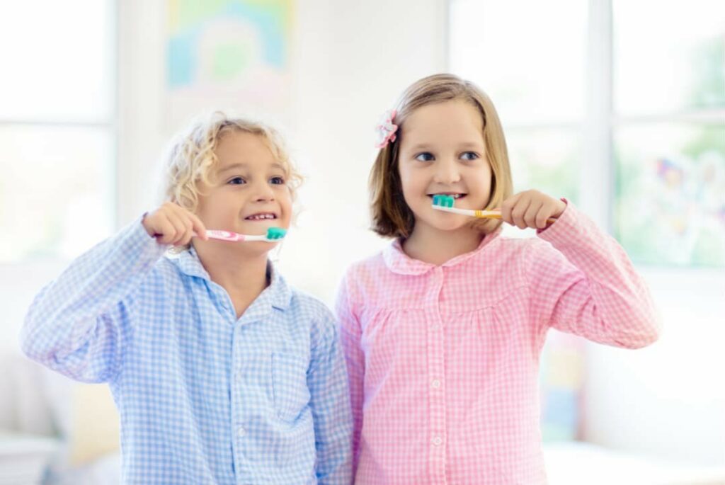 Children brushing teeth together